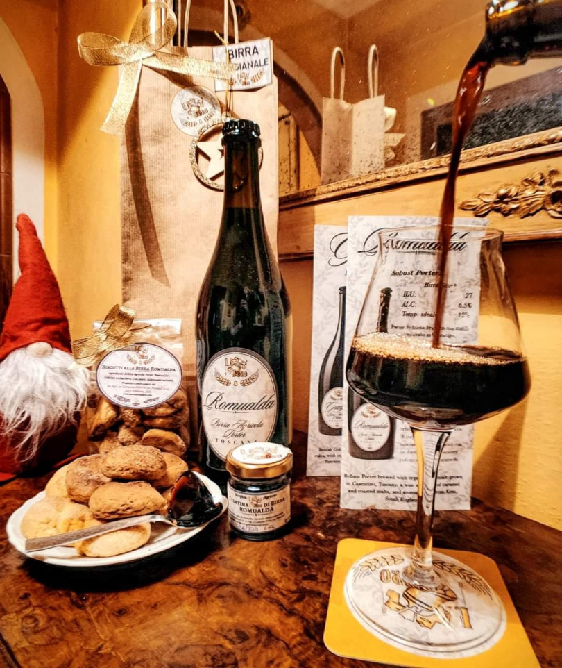 foto di un tavolo allestito con biscotti alla birra romualda e un bicchiere dove si sta versando la suddetta